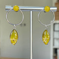 Boucles d'oreilles Aura Sajecréa, cercle argent 999 et fleurs d'Orpin blanc sur fond jaune solaire.