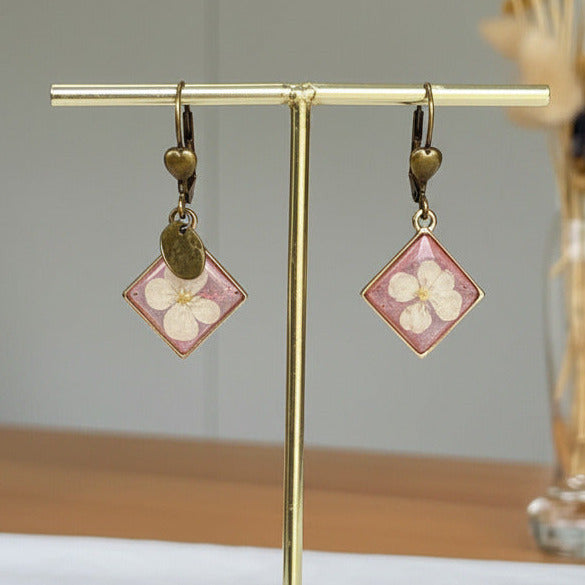 Boucles d'oreilles Éclat Bronze, résine rose transparente et fleurs d'Hortensia blanche.