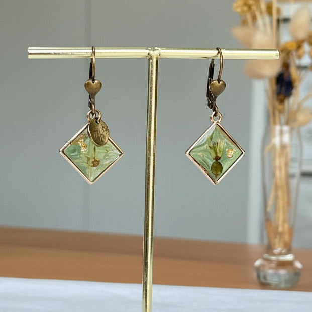 Bijou botanique bronze, carré vert transparent et fleurs de Bryone dioïque.